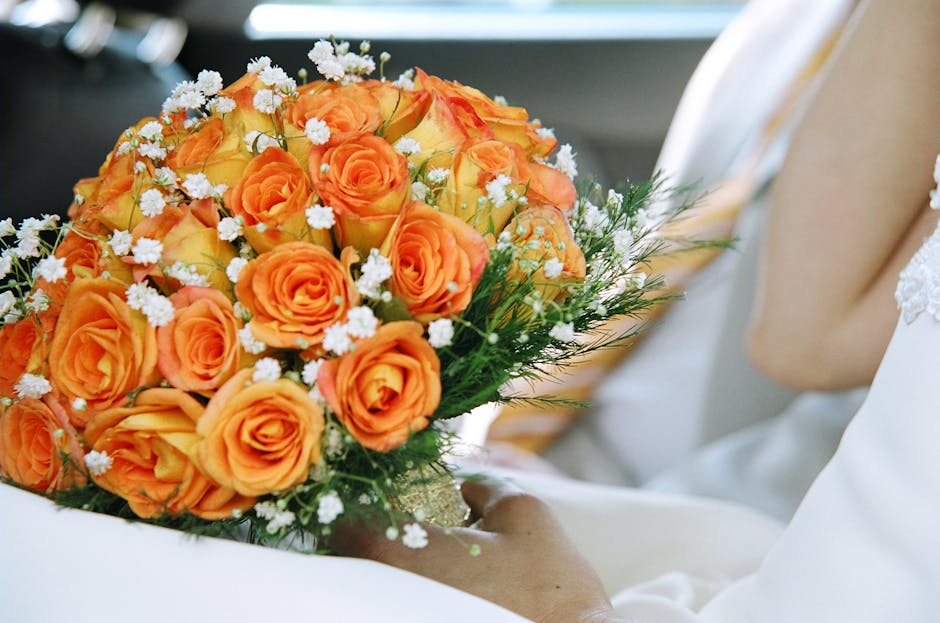 A close-up view of three vibrant floral bouquets featuring a mix of pink, blush, and cream roses with lush green foliage. The roses are arranged in a rounded, compact style, showcasing their velvety p